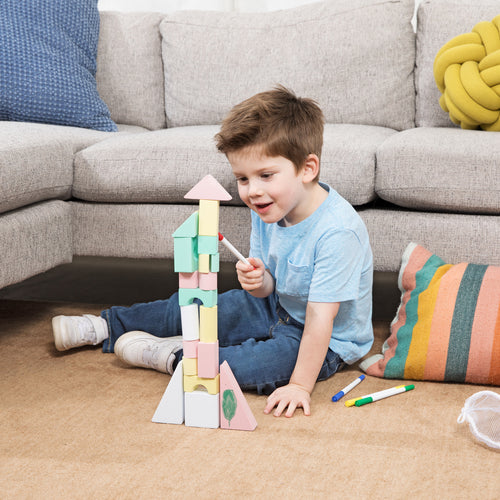 Child building with creative foam blocks after doodling