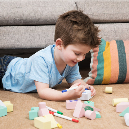 Child drawing on reusable Build n’ Doodle blocks